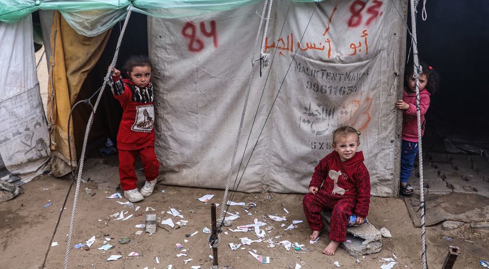 两名儿童站在加沙地带南部拉法的临时住所外