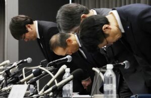 小林制药高管在日本大阪举行的新闻发布会上鞠躬致意