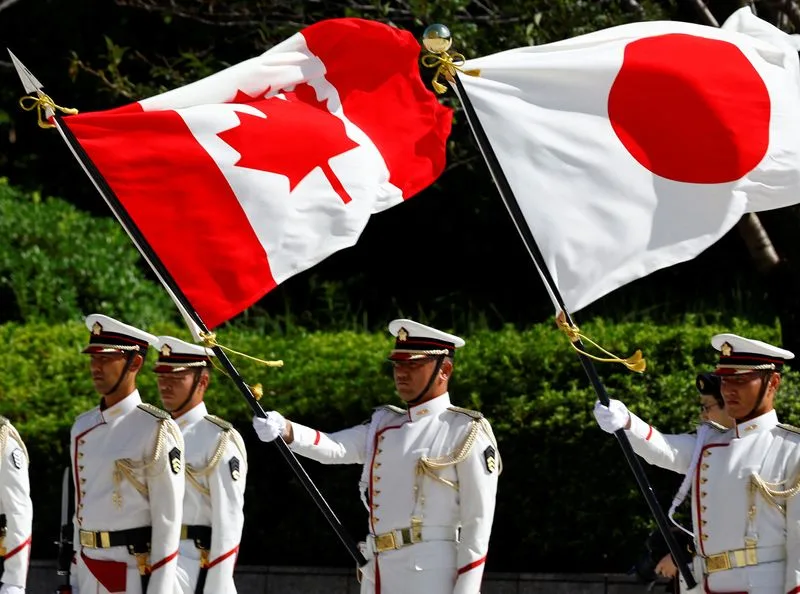 日本仪仗队在东京国防部举行的加拿大国防部长比尔·布莱尔欢迎仪式上举着加拿大和日本国旗